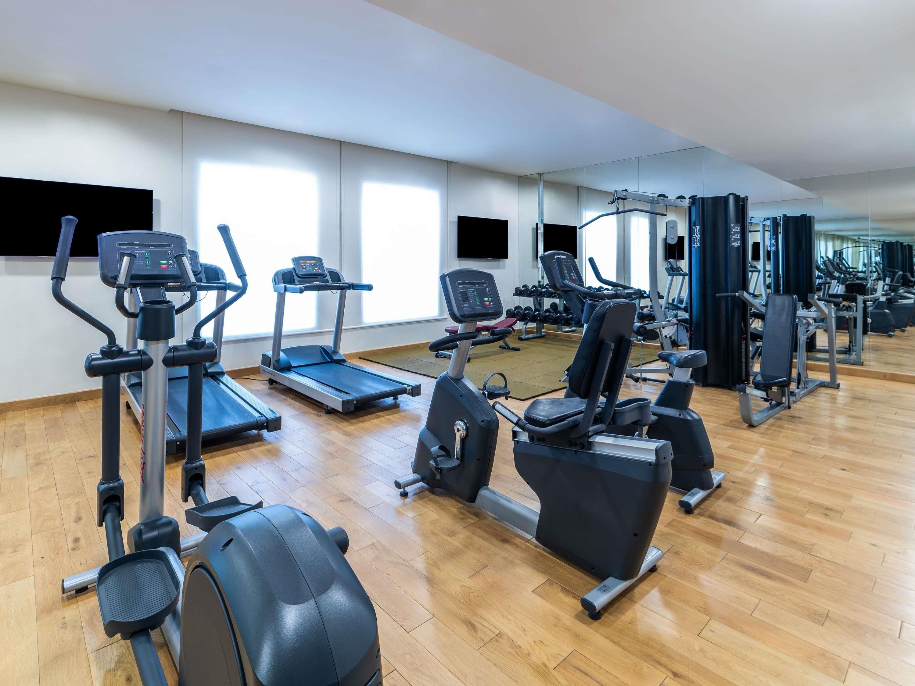 A gym with treadmills, elliptical machines, and weight equipment.