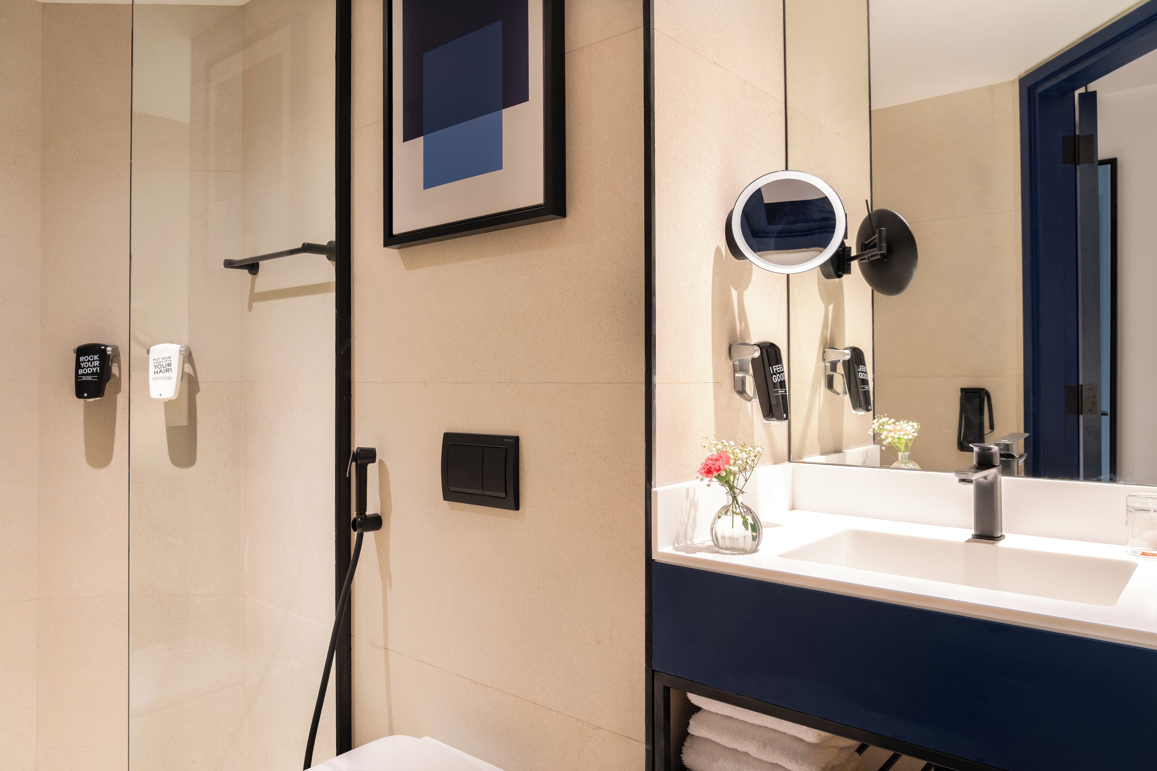 A modern bathroom with a large mirror, a sink, and a shower area.