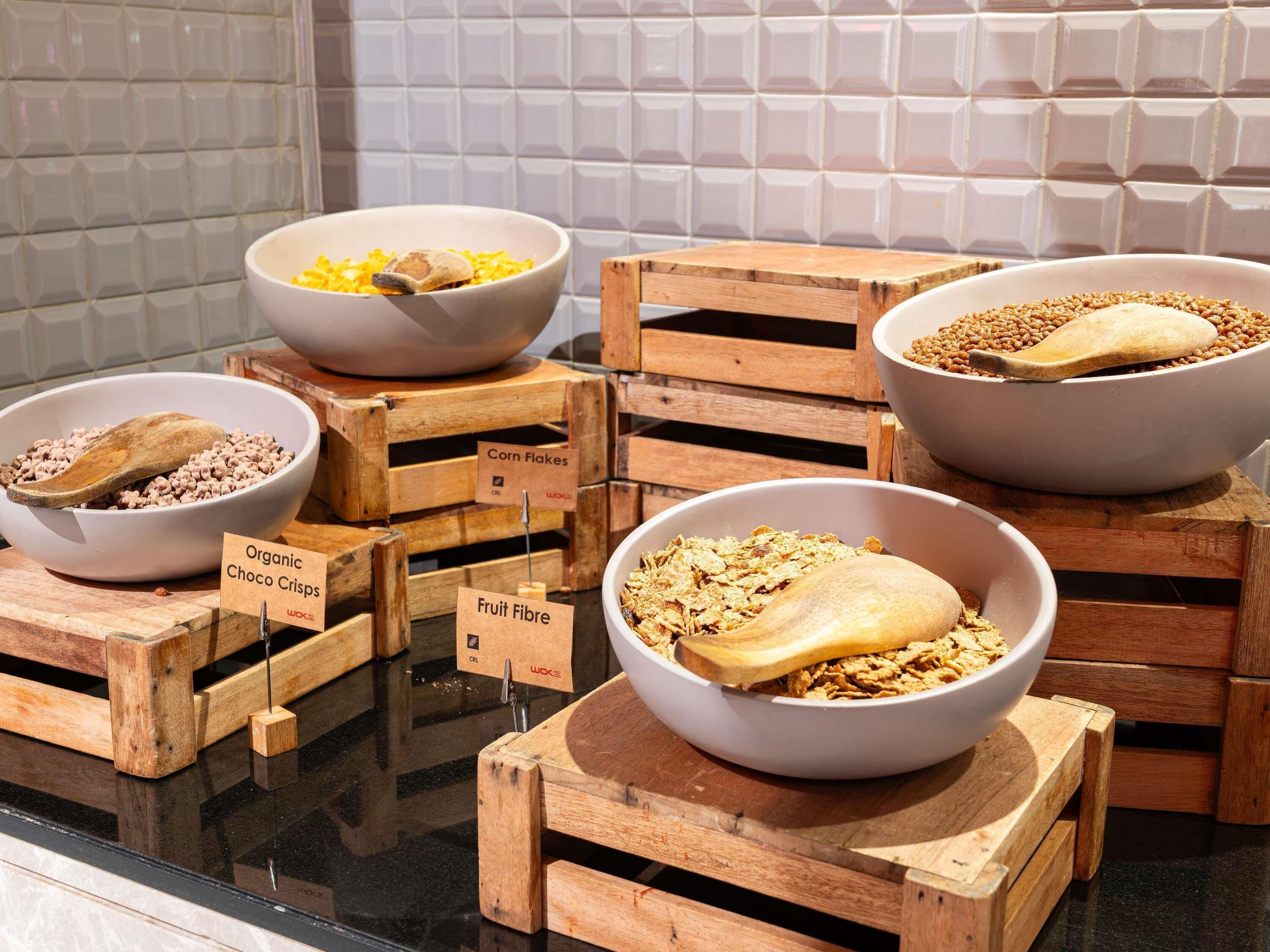 Una exhibición de diferentes cereales para el desayuno en cuencos sobre cajas de madera.