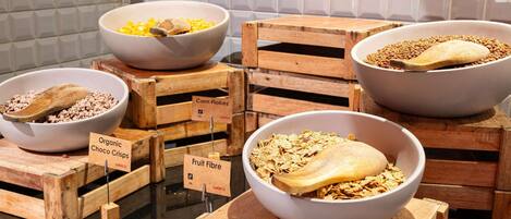 Una exhibición de diferentes cereales para el desayuno en cuencos sobre cajas de madera.