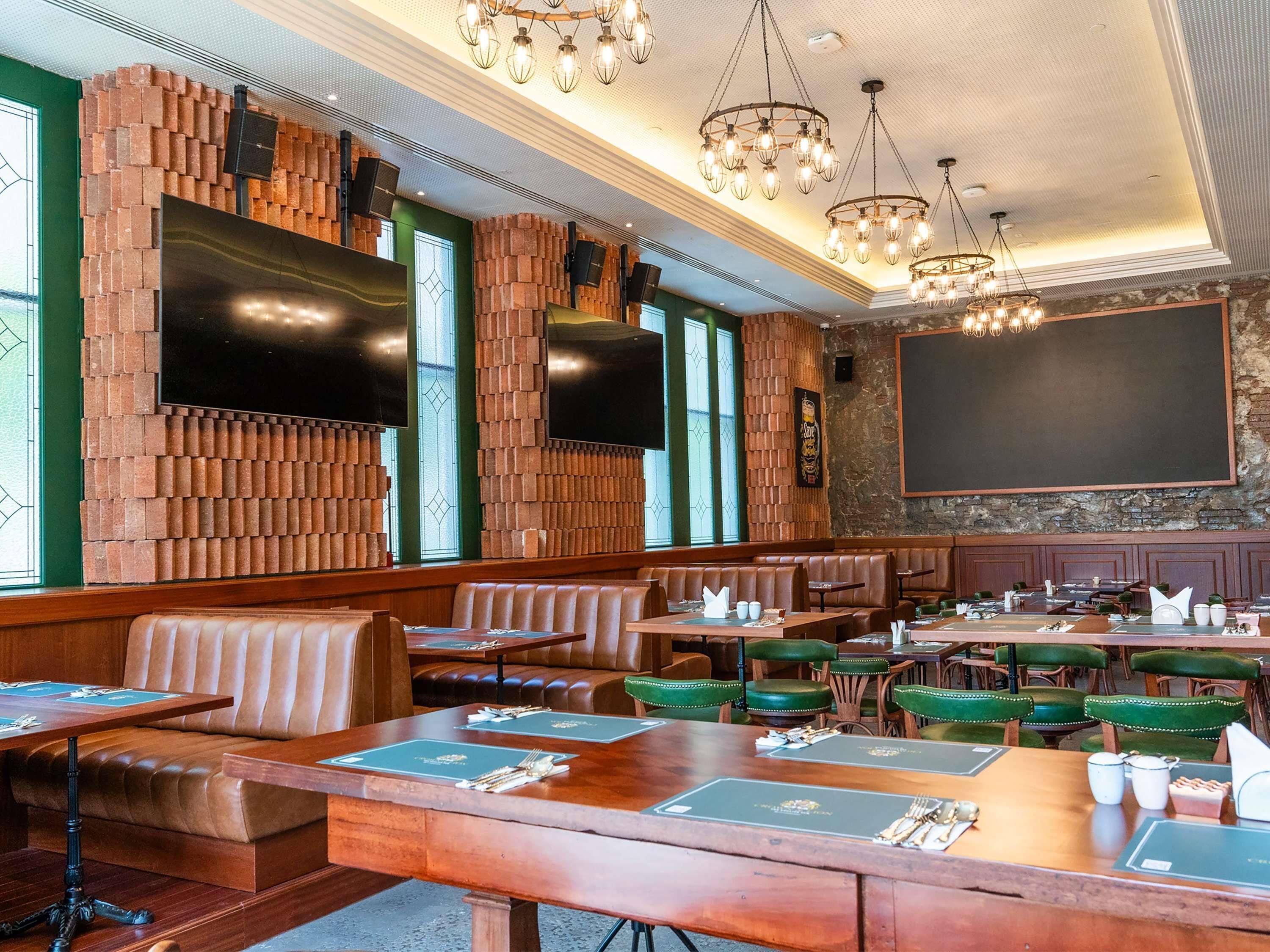 A restaurant with brick walls, wooden booths, and tables set for dining.