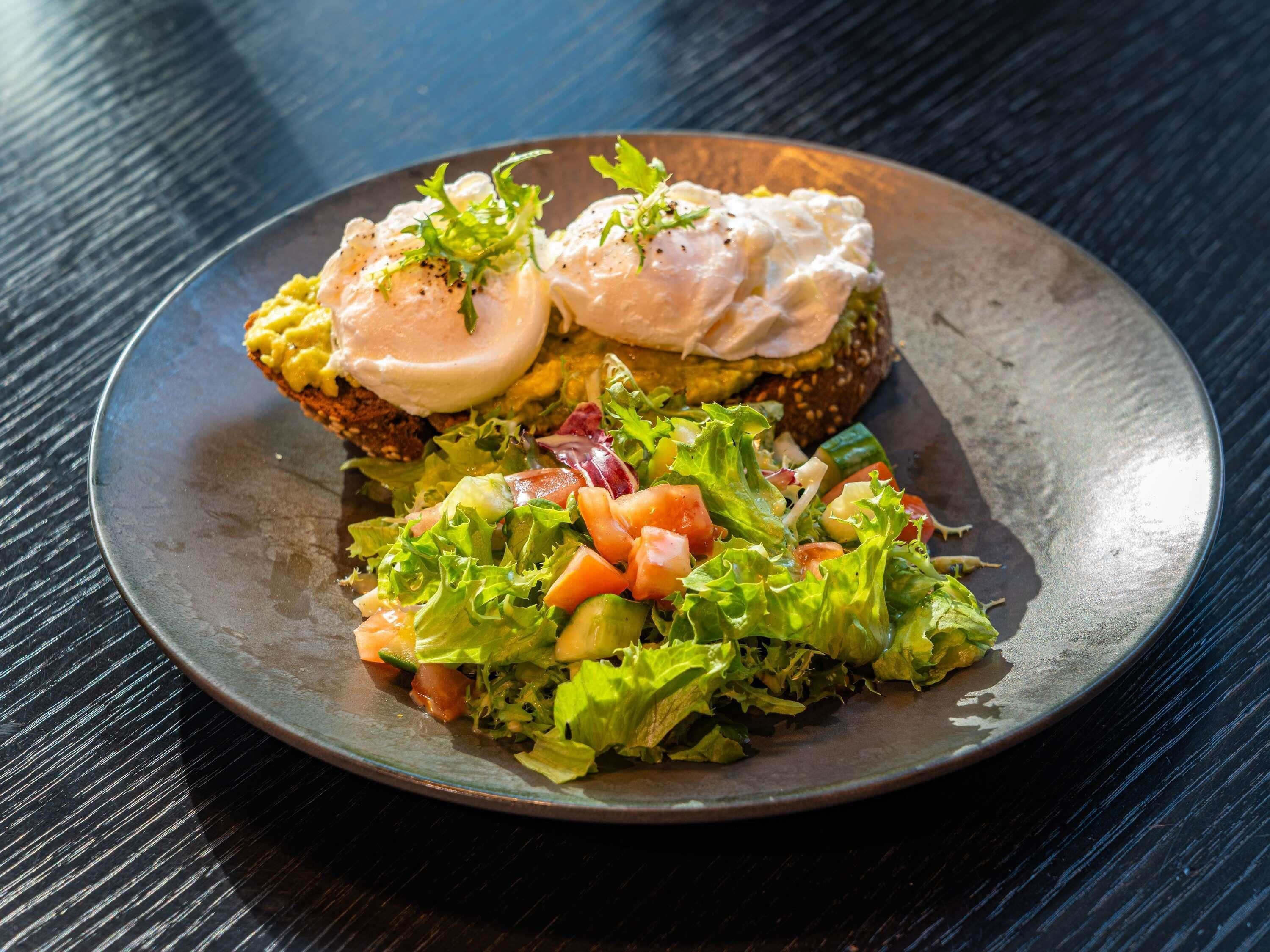 Une assiette avec un sandwich et une salade en accompagnement.