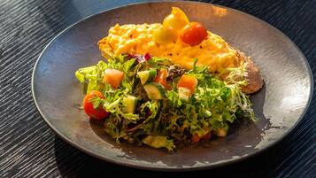 A plate with scrambled eggs, toast, and a salad.