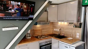 Eine moderne Küche mit Holzarbeitsplatte, Edelstahlgeräten und einem eingebauten Geschirrspüler.