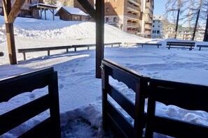 A snow-covered outdoor area with wooden benches and a wooden fence. - RisoulSki Constellation (Risoul)