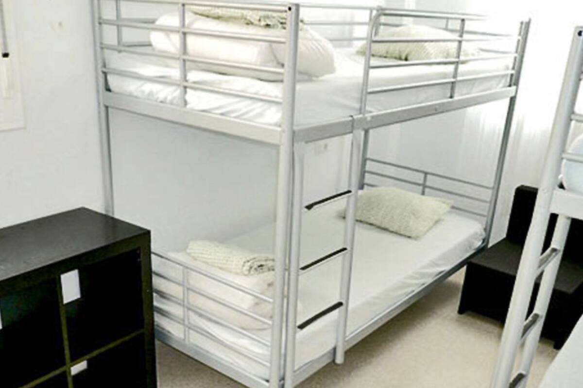 Quarto com beliche, uma escrivaninha e uma cadeira.