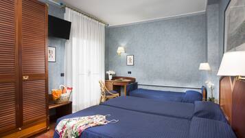 Ein Hotelzimmer mit einem großen Bett, einem Schreibtisch, einem Stuhl und einem Kleiderschrank.
