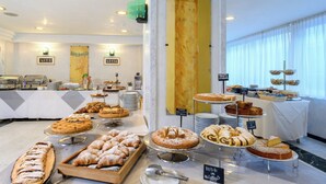 A buffet with various pastries and desserts, a yogurt station, and a sign indicating a crepe and chocolate option. - Hotel Atilius (Riccione)
