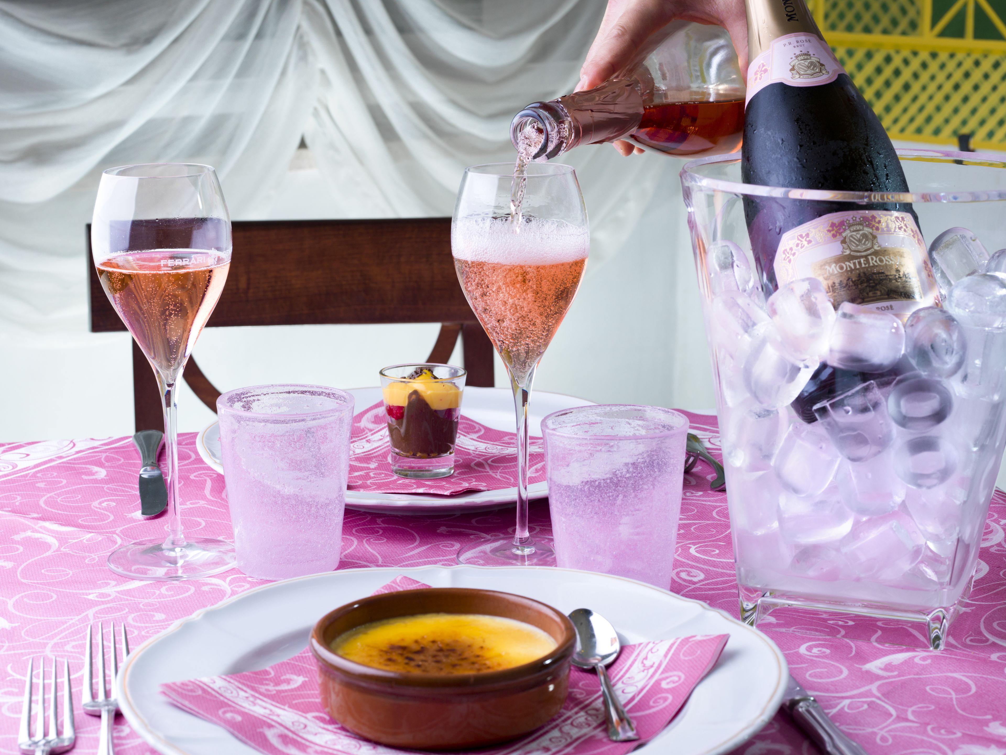 Una mesa servida con champán, copas y un postre.