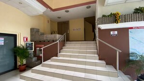 A staircase with handrails, a reception area with a desk and a plant, and a map on the wall. - Hotel 4 Ríos (Cuenca)
