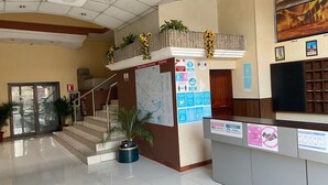 A reception area with a map, informational posters, a staircase, and a reception desk. - Hotel 4 Ríos (Cuenca)