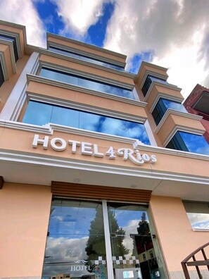 A hotel with a modern facade, large windows, and a sign that reads "HOTEL 4 RIOS". - Hotel 4 Ríos (Cuenca)