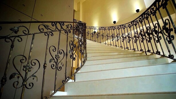 A staircase with ornate black metal railings and white steps. - VICTORIA STAR HOTELS & BUSINESS VILLAGES (Jincheng)