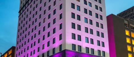A tall hotel with a modern design, featuring a prominent entrance and multiple floors.