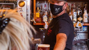 A bar with shelves of liquor bottles and a person serving a drink.