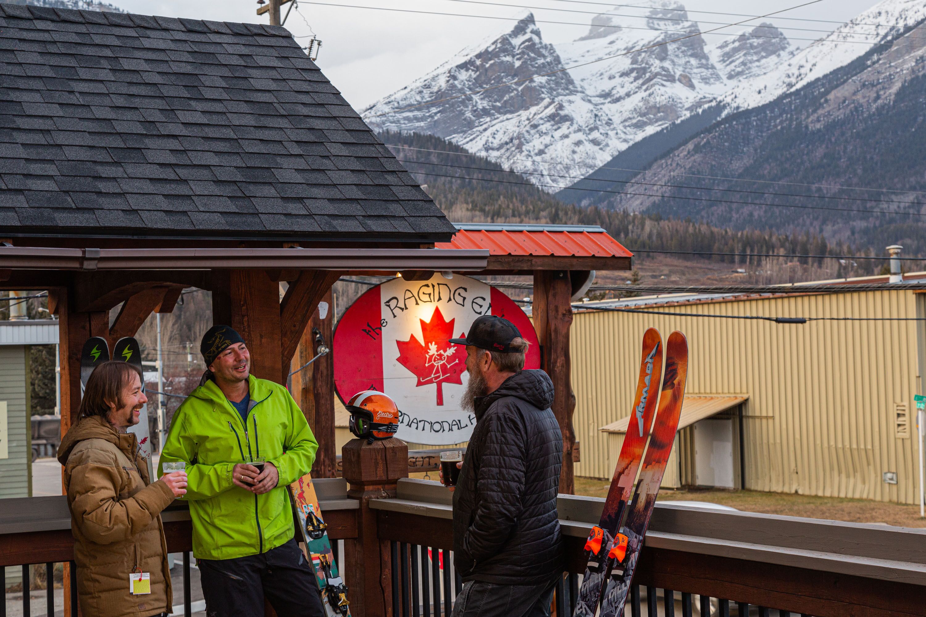A wooden structure with a sign reading "Racing Canada" and a backdrop of snow-capped mountains.