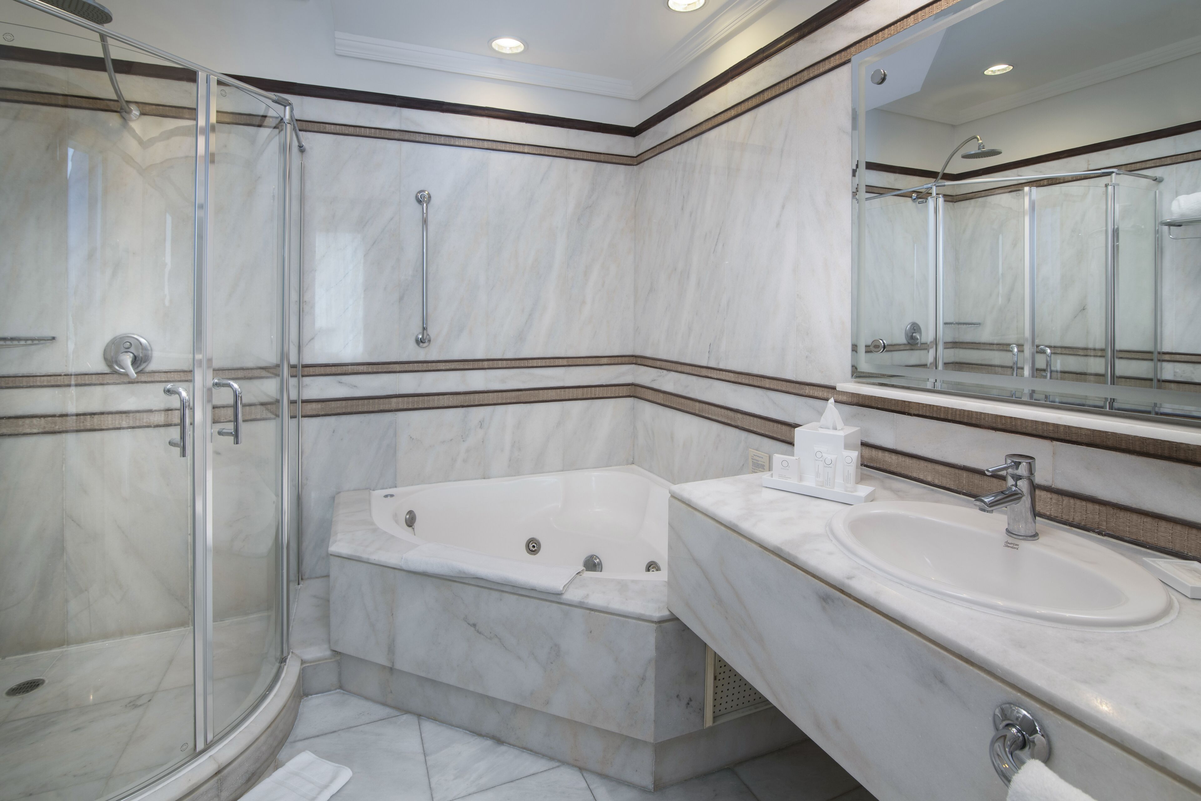 A modern bathroom with a glass-enclosed shower, a freestanding bathtub, and a vanity with a sink.