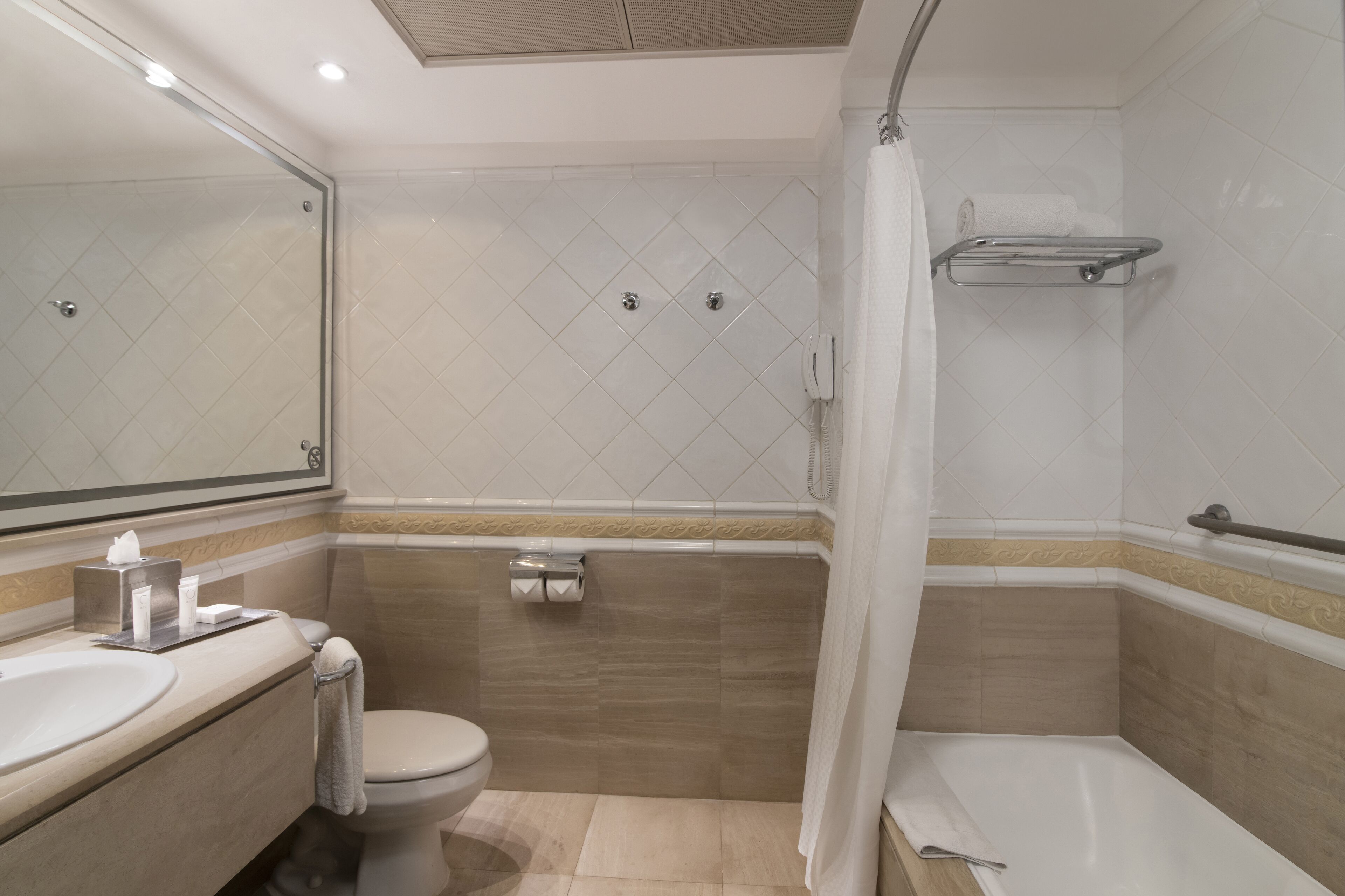 Une salle de bain comprenant des toilettes, un lavabo et un espace douche.