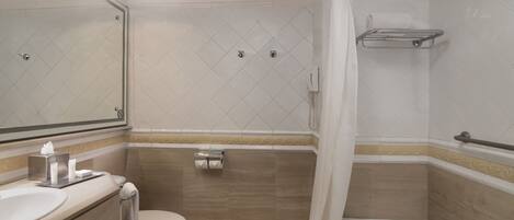 A bathroom with a toilet, sink, and shower area.