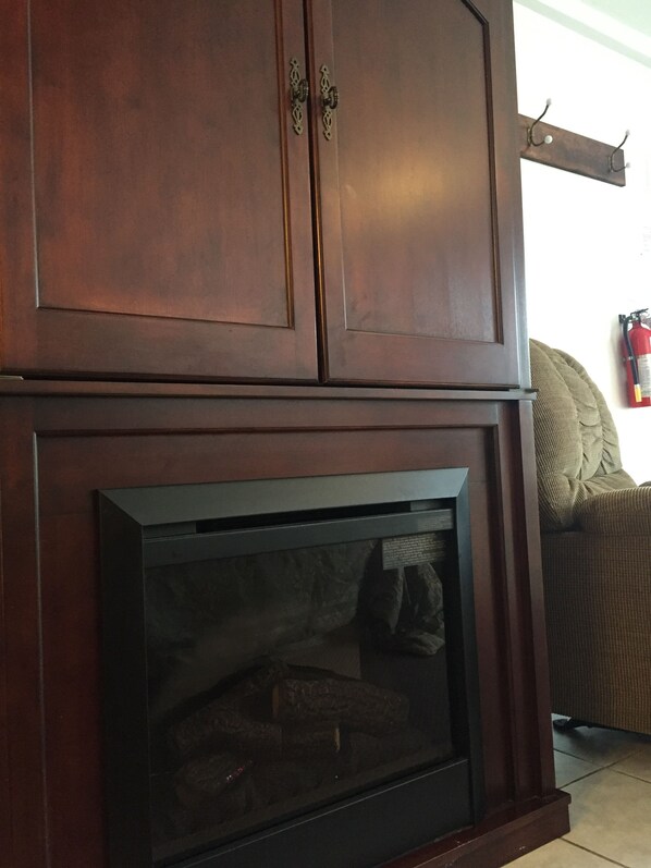A wooden cabinet with a built-in fireplace.