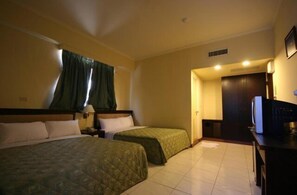 A hotel room with two beds, a desk, a television, and a door leading to another room. - Penghu Farmers Association Resort (Magong)