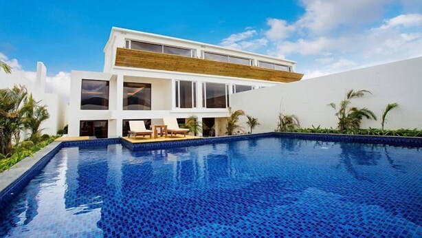 Una casa moderna de dos pisos con piscina delantera.