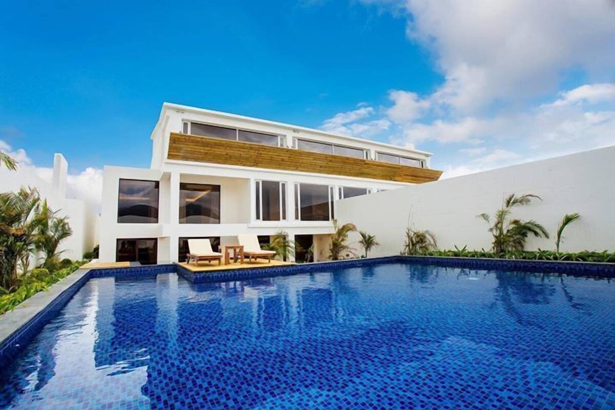 Una casa moderna de dos pisos con piscina delantera.