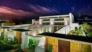 Un edificio moderno con un diseño arquitectónico único, que cuenta con varios niveles y un jardín en la azotea.