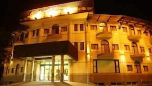 A multi-story building with a central entrance, balconies, and a warm exterior lighting. - Kenting Culture Resort (Hengchun)