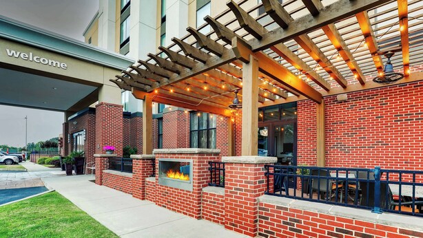 A brick exterior with a pergola and outdoor seating area. - Hampton Inn & Suites Rome (Rome)