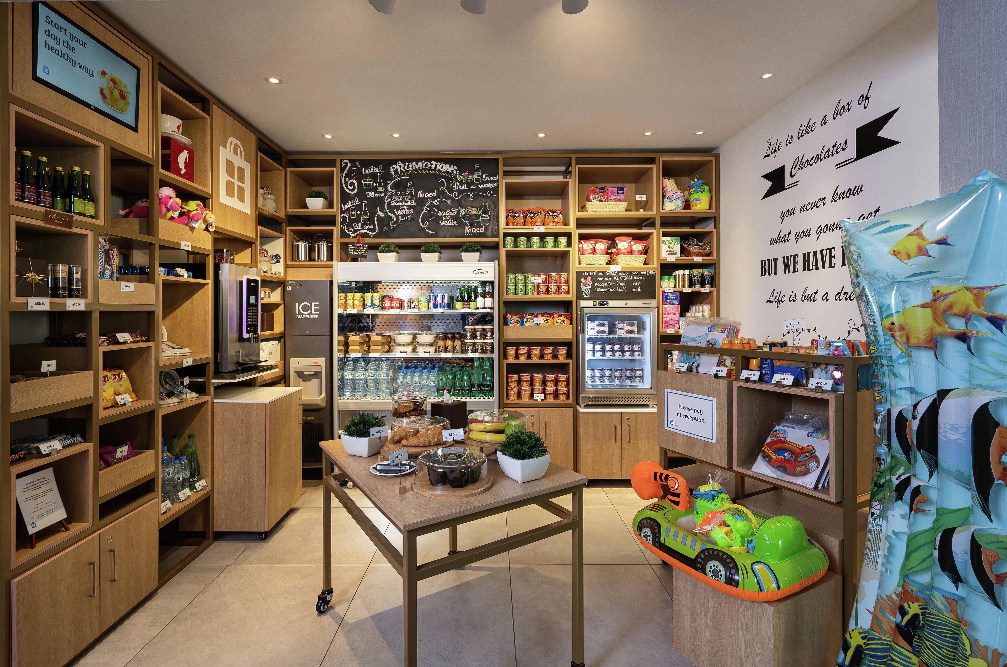 A well-organized store with shelves stocked with snacks, beverages, and a variety of products.