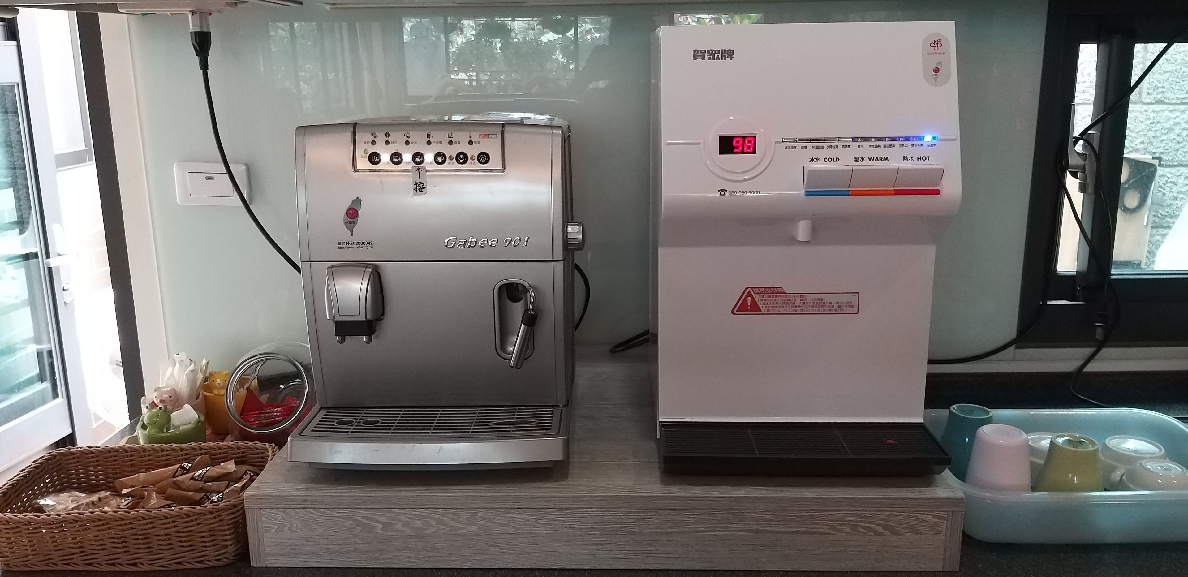 A coffee machine and a refrigerator in a kitchen area.
