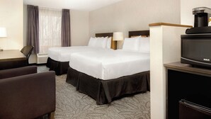 A hotel room with two beds, a desk, a chair, a television, and a coffee machine. - Quality Inn & Suites (Kingston)