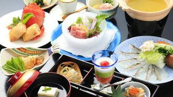 A variety of Japanese dishes including sushi, sashimi, and a bowl of soup, arranged on a table.
