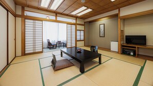 Una habitación japonesa tradicional con suelo de tatami, una mesa baja y puertas correderas.