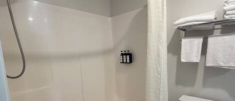 Un baño con bañera, ducha, inodoro y un perchero para toallas.