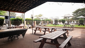 An outdoor patio area with picnic tables and a pool table. - Royal Hotel Singleton (Singleton)