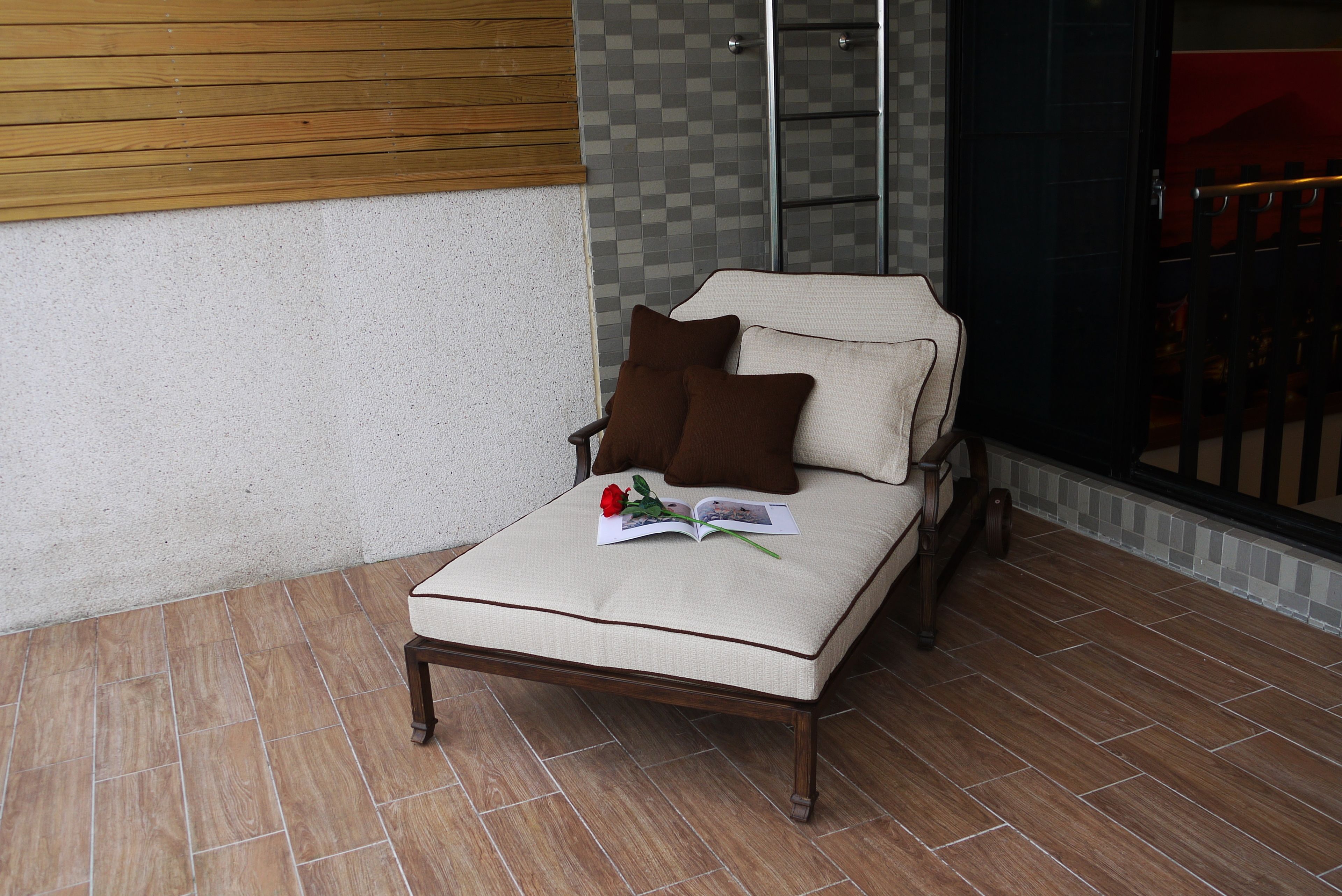 A small, single-bed room with a wooden headboard, a pair of brown pillows, and a book on the bed.
