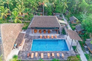 Alberca al aire libre, sombrillas en la alberca y camastros 