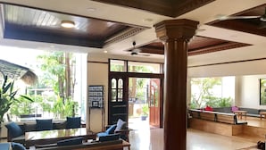 Eine geräumige Lobby mit hoher Decke, Holzbanken und einer großen Säule.