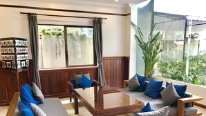 Ein modernes Wohnzimmer mit einer Sofagarnitur, einem Couchtisch aus Holz und einem Bücherregal.