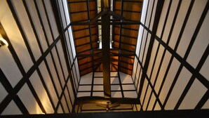 A view of a room with a wooden ceiling and a ceiling fan.