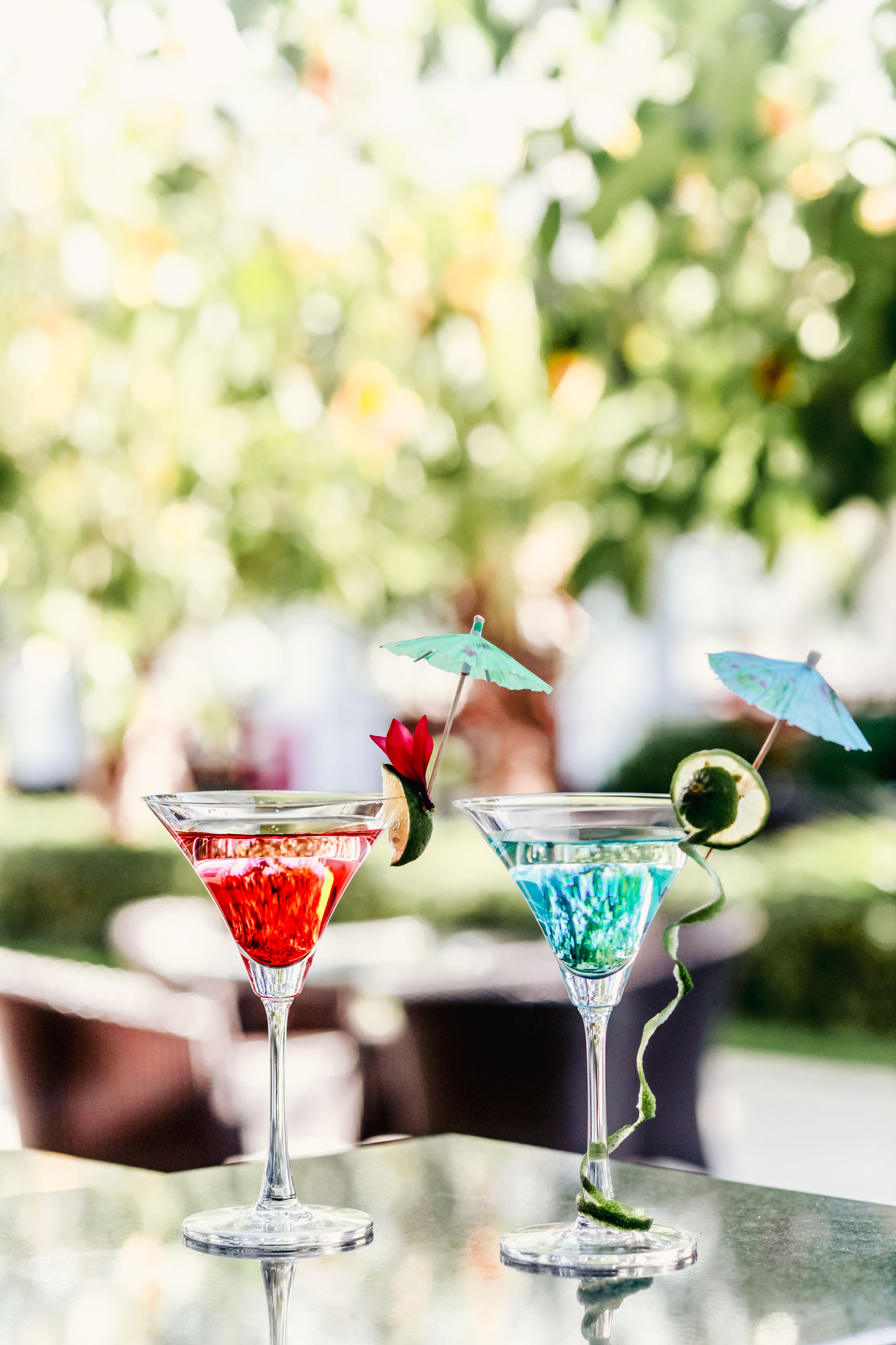 Due bicchieri di martini su un tavolo con uno sfondo sfocato all'aperto.