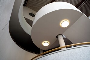 A modern architectural design with a circular structure and a central light fixture.