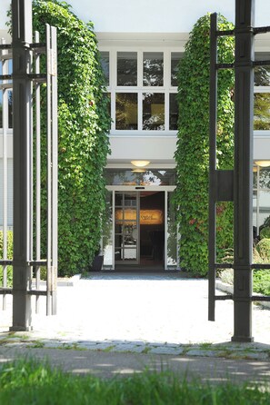 A building with a covered entrance, a sign reading "Rafael's Place," and a glass door.