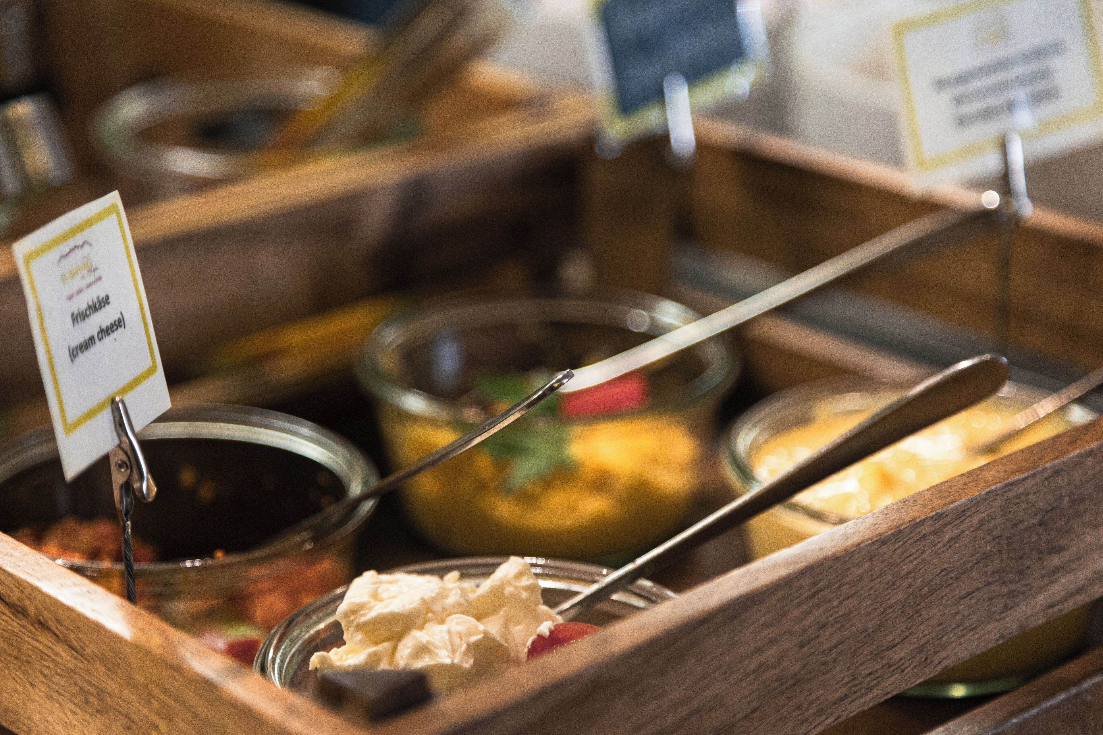 A buffet with various food options, including a sign for fresh cheese.