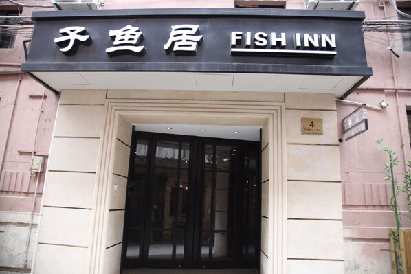 Exterior de um edifício com uma placa que diz 'Fish Inn'.