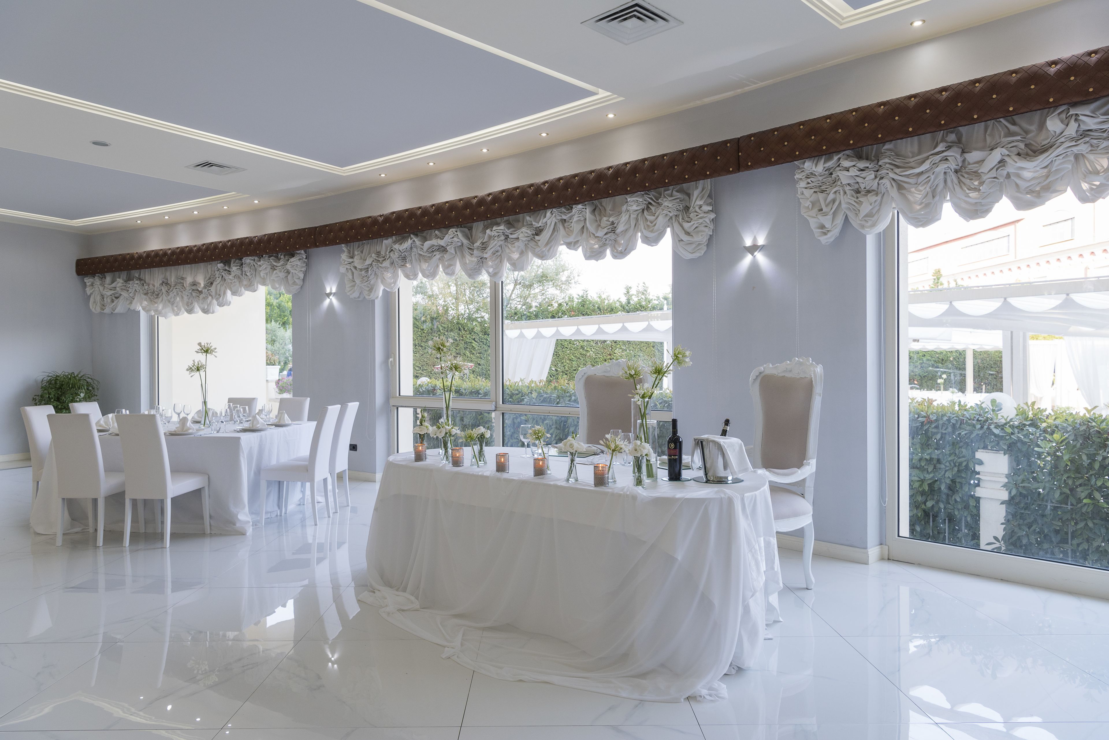 A spacious room with a large dining table set for a meal, surrounded by chairs.