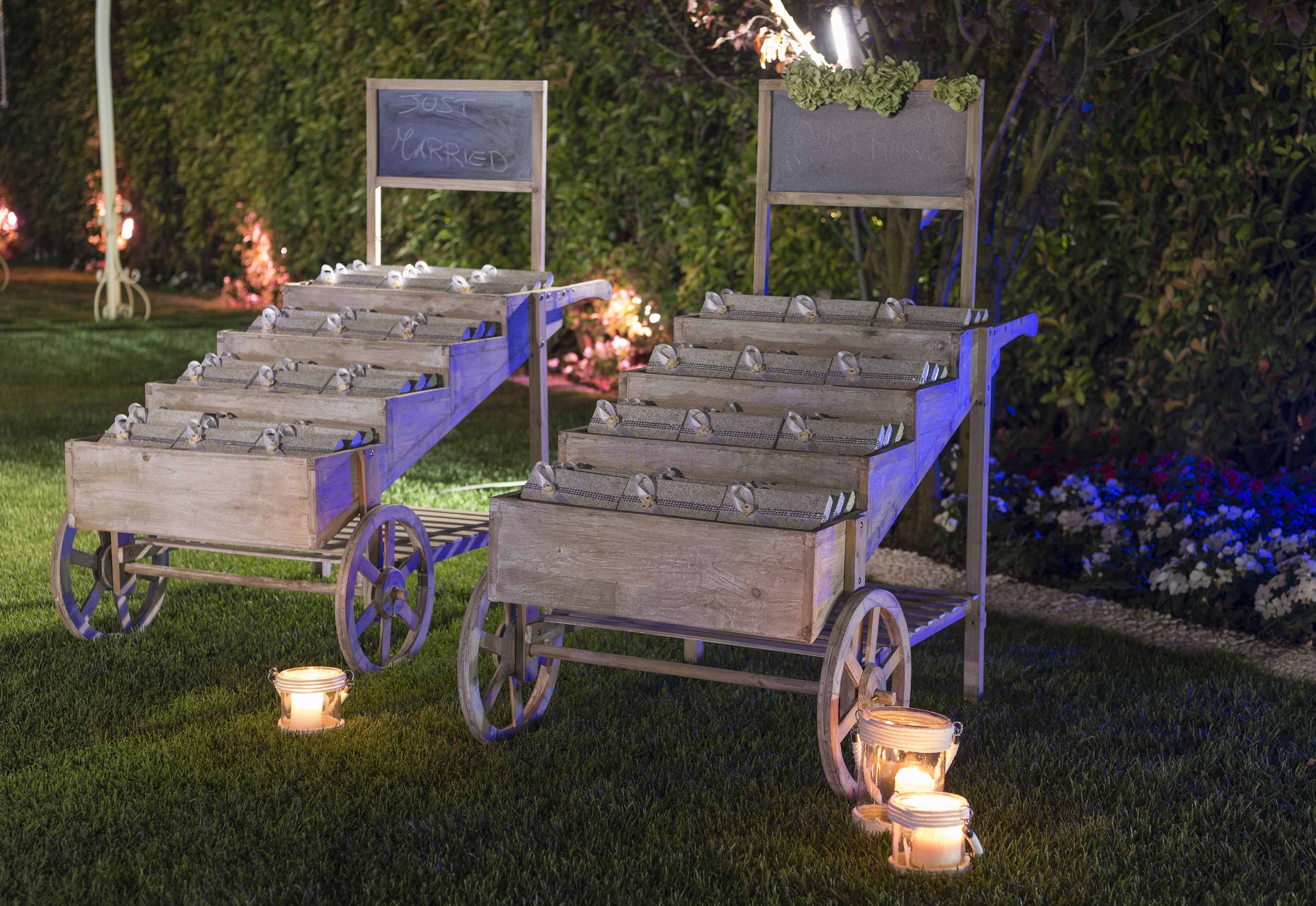Two wooden carts with metal seats, each with a sign above.