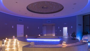 A spa area with a circular hot tub, a staircase, and a ceiling with a starry design.